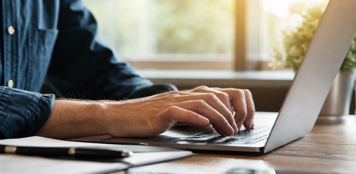Hands typing a thoughtful review reply on a laptop, suggesting prompt follow-through
